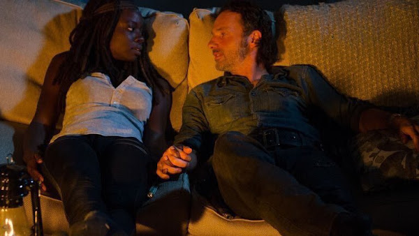 Michonne and Rick holding hands on the couch