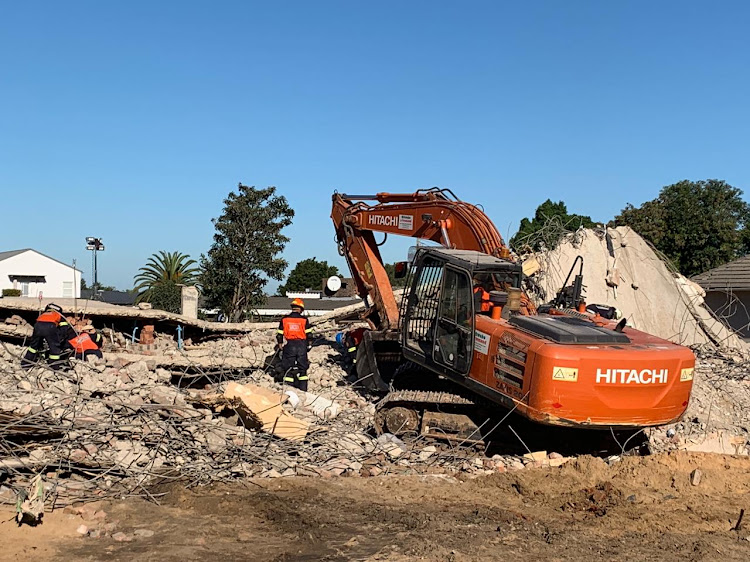 Heavy equipment being used to break up the concrete in the search for survivors at the site of the collapsed building in George on Thursday.