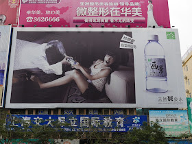 advertisement for Va Kin (画景) spring water including an image of a ghost woman coming out of a TV screen and trying to take away a bottle of water from a frightened woman