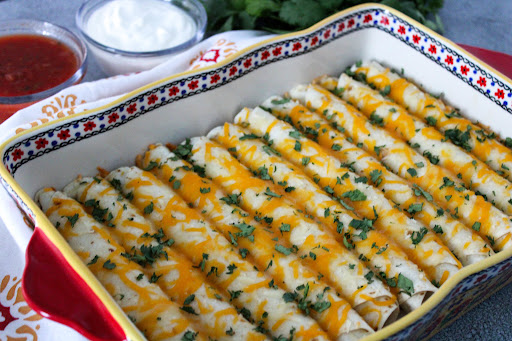 A dish of Shredded Pork Taquitos with cilantro sprinkled on top.