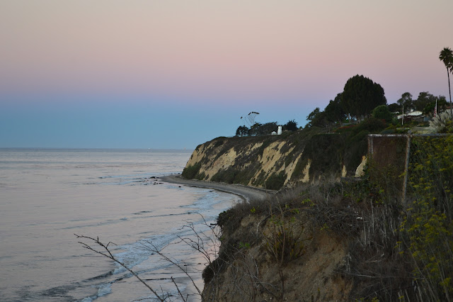 pink sky and a light house