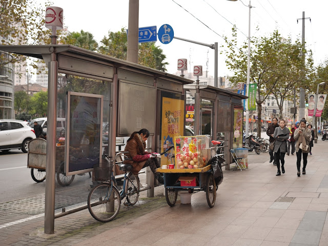 woman selling fresh pomegranate juice sitting next to her tricycle cart