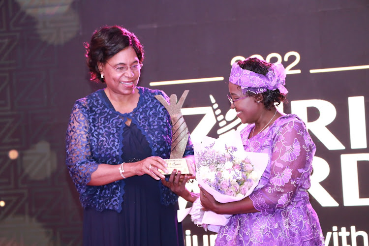 Margaret Kobia, Cabinet Secretary, Ministry of Public Service and Gender giving an award to Ruth Samoei for her role in facilitating disadvantaged deaf communities to favourably compete for available business opportunities in an already saturated market at the 2022 ZURI AWARDS held in Nairobi.