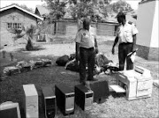 THUGS' BOOTY: Spokesman for the Mpumalanga organised crime unit Captain Leonard Hlathi, left, and Senior Superintendent Mike Mhlanga, who is in charge of police at the Lebombo border post, inspect some of the goods stolen from schools  and businesses in Mpumalanga.Pic. Riot Hlatshwayo. 22/10/2008. © Sowetan