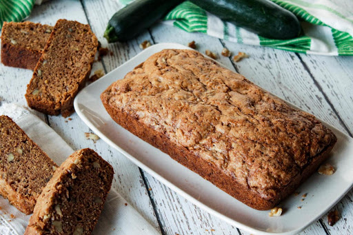 Loaf of baked zucchini bread with 4 slices.