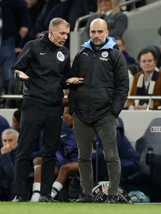 Manchester City manager Pep Guardiola speaks to a match official