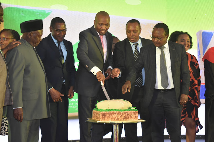 CS Moses Kuria - centre- cutting the cake in Athi River on Tuesday.