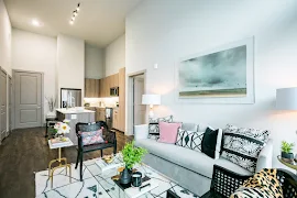 Living room facing kitchen with track lighting above kitchen island featuring high ceilings throughout 