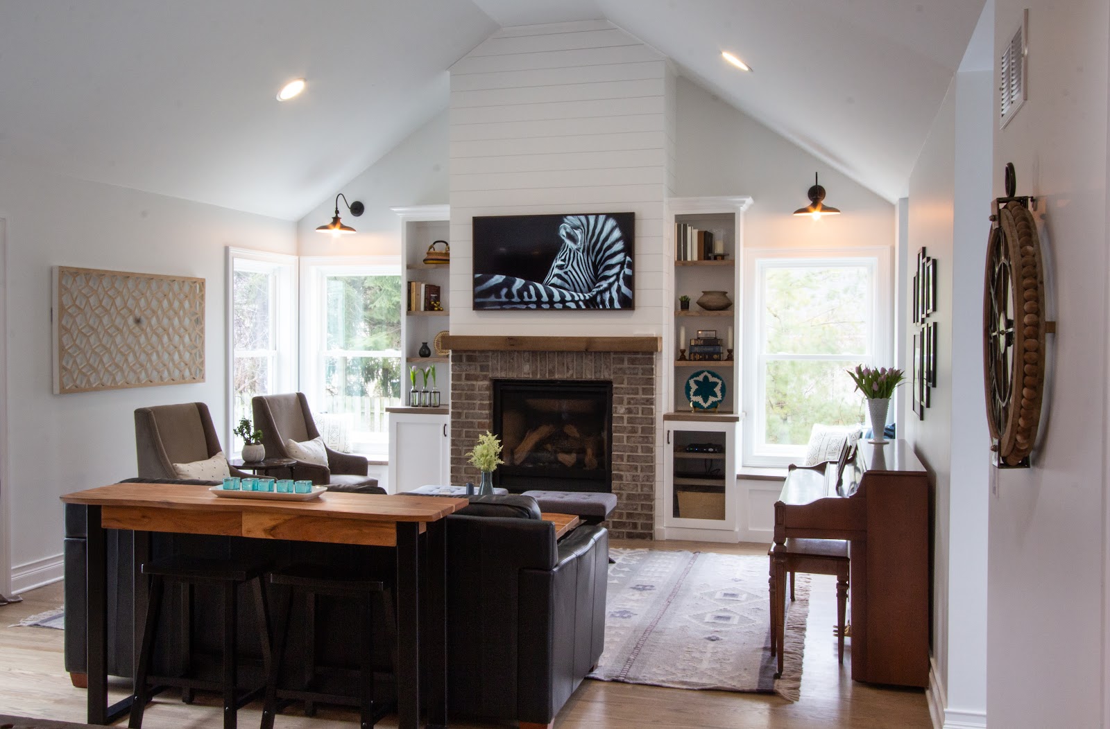 Family room addition with fireplace flanked by build in shelving on either side and window seats