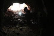 A youngster lights a cellphone torch inside the dingy mine shaft in search of zama zamas in Munsieville, Krugersdorp, on Friday.