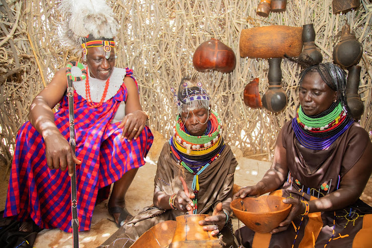 President WIlliam Ruto interacting with elderly women who are preparing porridge at the Turkana Cultural Festival on October 12, 2023