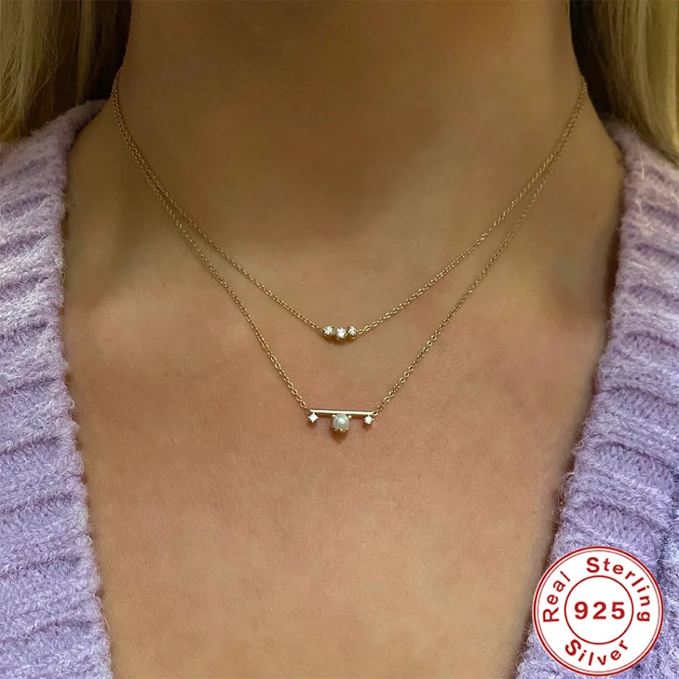 Mode ketting met ronde zirkonia bar, ingelegd met parel en klauw. Verfraai je outfit met elegantie en schittering. Perfect voor elke gelegenheid.