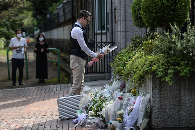 A man offers flowers in front of the British embassy in Tokyo, Japan on September 8 2022.