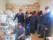 Members of the SAPS in the Northern Cape and the arrested suspects who are accused of allegedly selling counterfeit goods in Hartswater on July 17 2018 