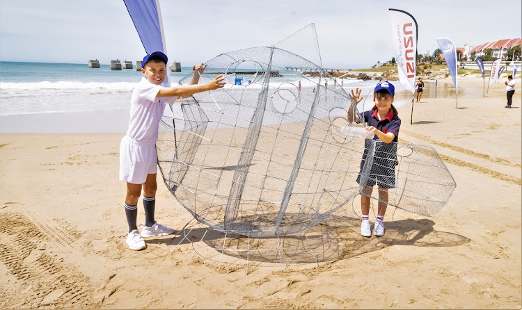 GARBAGE GOBBLER: Bay residents Gabriel and Jemima Reilly with the wire model of Munch the coelacanth