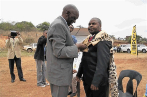 HALALA: Chief John Xikundu, left, dresses new chief Samuel Mkhari in his leopard skin at his swearing in ceremony at Briboni in Elim in Makhado on Friday. PHOTO: Benson Ntlemo