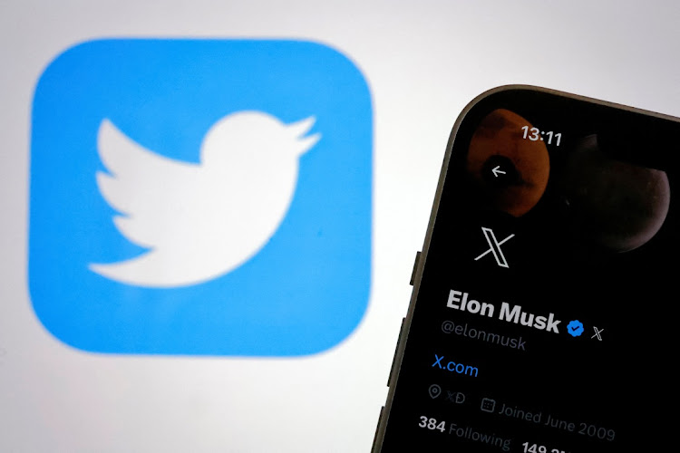 The new logo of Twitter is seen on Elon Musk’s Twitter account on an iPhone as the old Twitter logo is displayed on a MacBook screen in Galway, Ireland