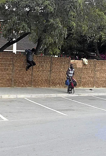 Two homeless people jumping over a wall at the YMCA in Orlando East after being moved there from the city.