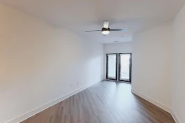 Living room with patio door with blinds, ceiling fan, wood plank flooring, and white walls and trim