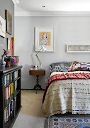 The main bedroom is filled with art and a rich layering of fabrics. Above the bed is  an artwork by Gina Waldman.