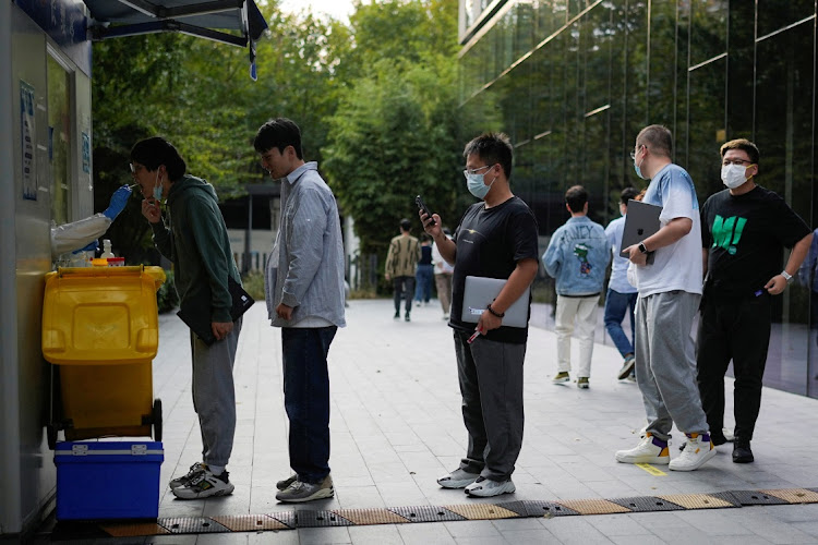 People line up to get tested for the coronavirus disease at a nucleic acid testing site at an office building in Shanghai, China, on November 3 2022. Picture: REUTERS/ALY SONG