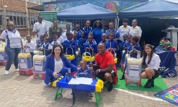 Akani Simbine, in red top, poses with Isekelo Primary School pupils and MiDesk Global innovators' Talita Boodhram, in white top (front right), and her mother Farana, in blue (front left).