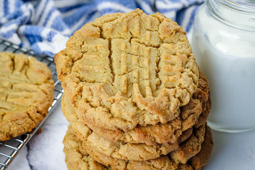 A stack of Peggi's Gigantic Melt In Your Mouth Crispy Peanut Butter Cookies.