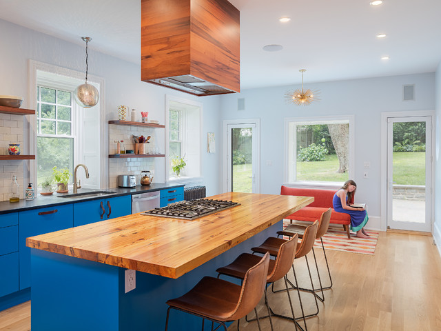 This sleek reclaimed wood countertop contrasts vibrant blue cabinets for a bright and colorful design.