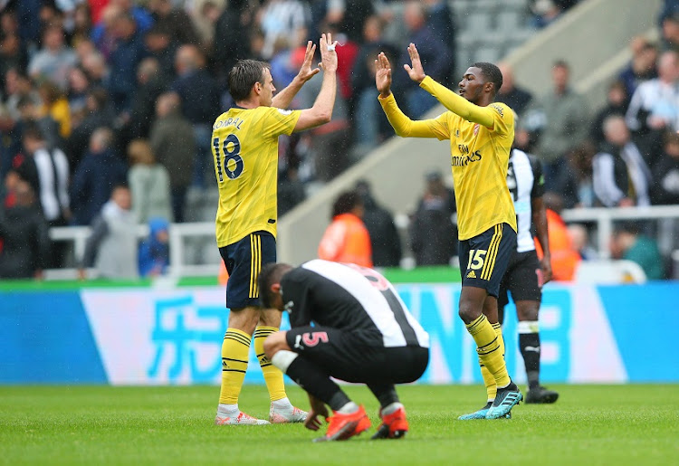 Nacho Monreal and Ainsley Maitland-Niles of Arsenal celebrate victory at full-time after the Premier League match between Newcastle United and Arsenal FC at St. James Park on August 11, 2019 in Newcastle upon Tyne, United Kingdom.