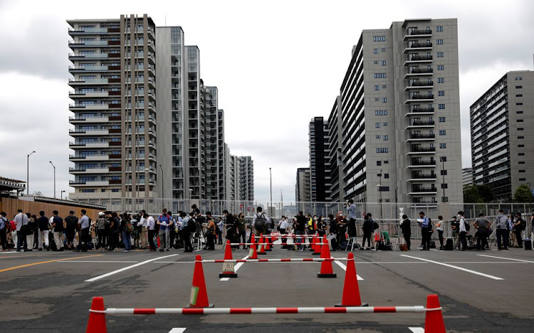 Journalists stand in a line to enter the village plaza of the Tokyo 2020 Olympic and Paralympic Village for a press tour in Tokyo, Japan, June 20, 2021. REUTERS/Kim Kyung-Hoon