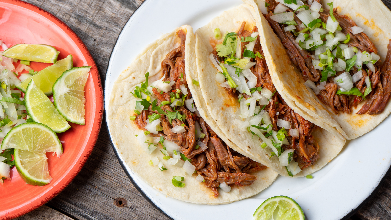 Foto de tacos en un plato con limas.