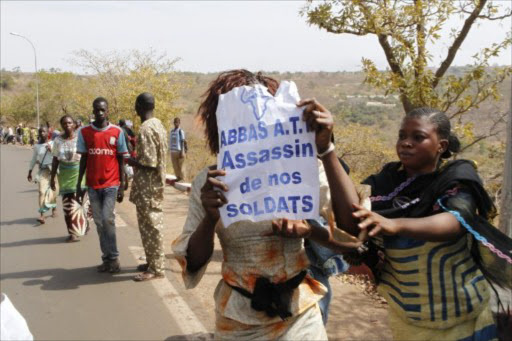 Women hold a placard reading "A.T.T (Amadou Toumani Toure) Assassin of our Soldiers" during a protest of relatives and supporters of soldiers fighting rebels Tuareg in the north against the "weak" response to attacks by the rebels, in Bamako