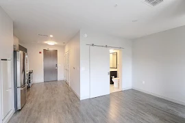 Living area and kitchen space with hardwood flooring and nurtural colored walls