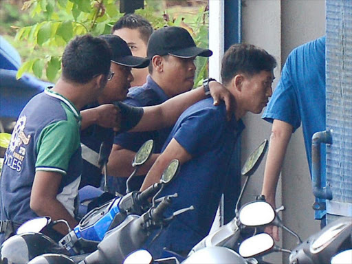 A North Korean man (R) identified by the Malaysian police as Ri Jong Chol and suspected by the authorities to be in connection with the murder of Kim Jong Nam, is taken to a police station in Sepang, Malaysia, February 18, 2017. /REUTERS