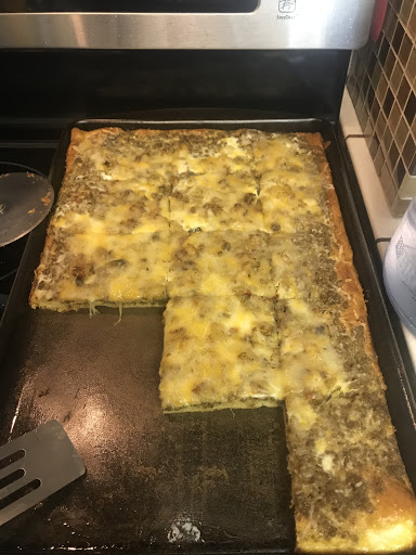 Yummy breakfast Pizza, a meal in a slice - eggs, hash browns, sausage and gooey cheese. 