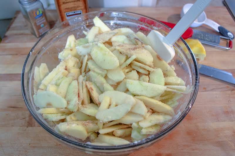 Tossing Apples With Sugar, Flour, Lemon Juice, Lemon Zest, Salt, And Spices.