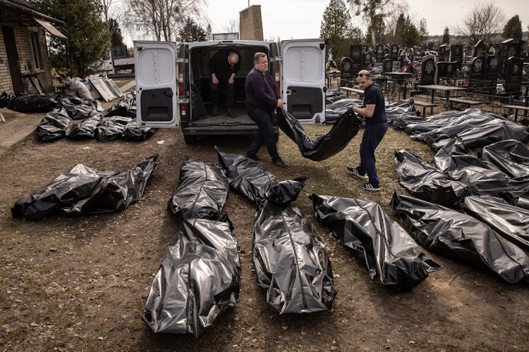 Cemetery workers unload bodies of civilians killed in and around Bucha, Ukraine, before they are transported to the morgue at a cemetery on April 7 2022.The Ukrainian government has accused Russian forces of committing a “deliberate massacre” as they occupied and eventually retreated from Bucha. Picture: CHRIS MCGRATH