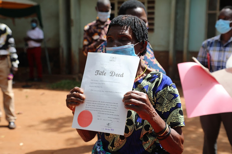 A resident of Malindi shows her tittle deed