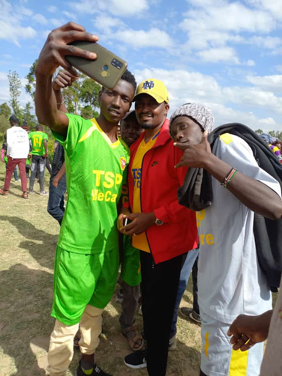 TSP Leader Mwangi Kiunjuri takes a selfie with footballers at Matanya grounds on Sunday. He announced he is running for the Laikipia East MP set in August