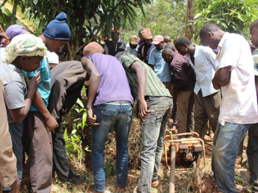 Residents mill around the scene where the body of the two-year-old girl was found. /COURTESY