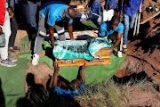 The tiny coffin of 11-month-old Ayabonga Makholwa is lowered into the ground at Mophela Cemetery in Hammersdale, west of Durban, on April 22 2022. The infant was buried alongside her four siblings who died when their home collapsed on April 11 in the Mangqondo area.