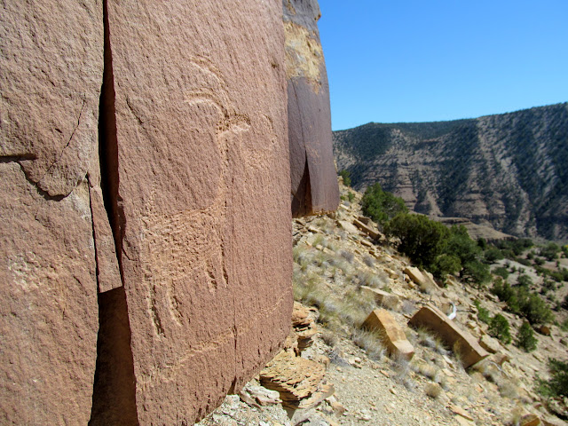 Two bighorn sheep petroglyphs, with line extending around the corner