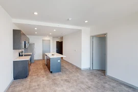 Living room with light walls and view of kitchen