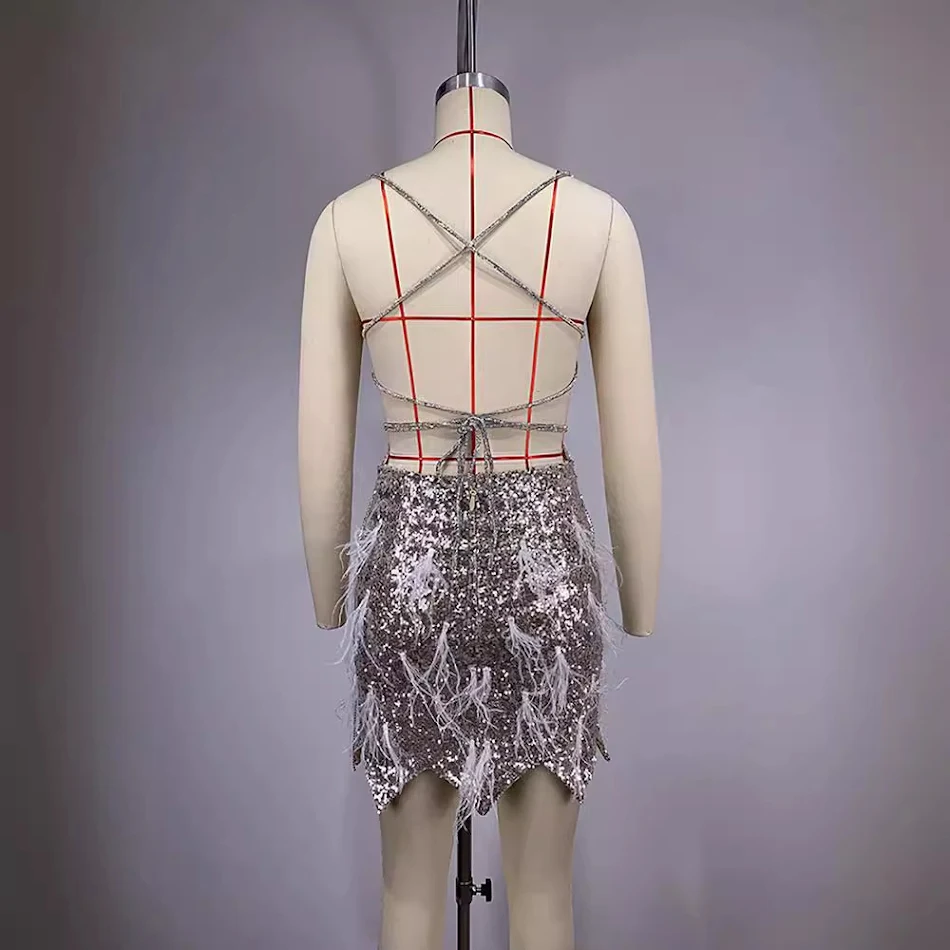 Abito estivo da donna con paillettes, piume e nappe, senza schiena. Perfetto per feste e serate estive, un look elegante e alla moda.