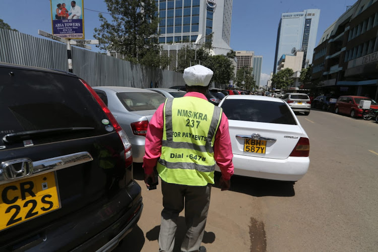 Nairobi County Parking attendant walks past the parking lot along Loita Street in Nairobi on February 16, 2022