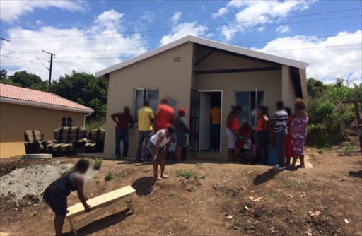 Community members gathering outside the Ilinge township home where five people died this morning. Picture: ZWANGA MUKHUTHU