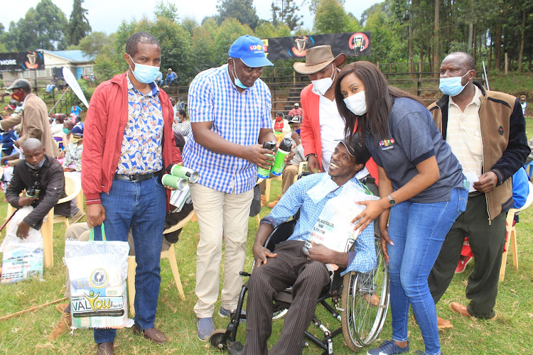 Gatanga MP Nduati Ngugi, Ahadi Kenya CEO Stanley Kamau and Lotto CEO Wangari Mwaura hand out foodstuffs on Friday.