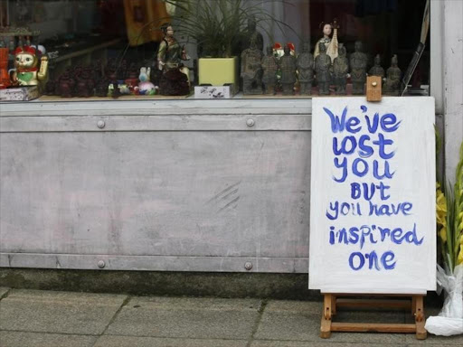 A sign and flowers stand outside a shop near to where murdered Member of Parliament Jo Cox's funeral cortege will pass in northern Britain, July 15, 2016. /REUTERS