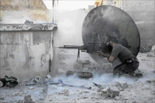 FIGHTING BACK : A member of the Free Syrian Army shoots at a government sniper in Aleppo. Meanwhile, government forces have regained the town of Qusair, near LebanonPHOTO: REUTERS