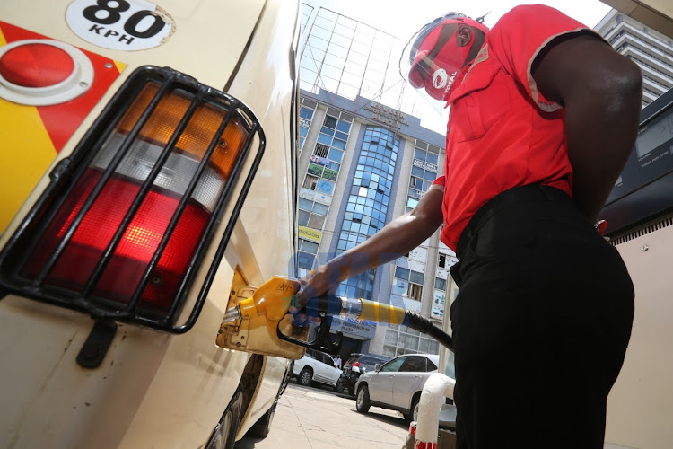 A fuel attendant fuels a car at Total Petrol station along Kimathi Street in Nairobi on July 14, 2020.